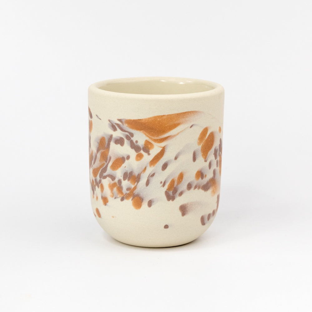 Ceramic cup with marbled design on a white background