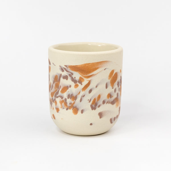 Ceramic cup with marbled design on a white background