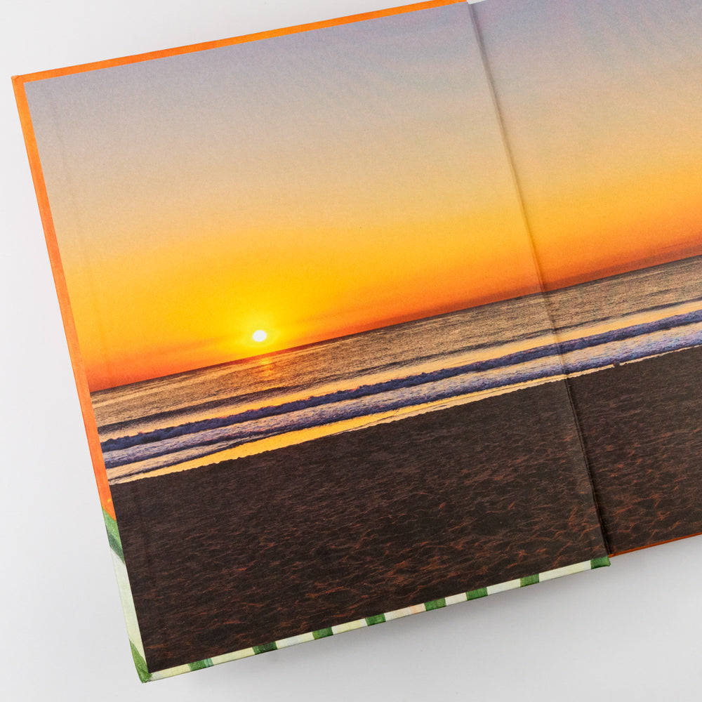 Book with a sunset over water and beach scene on the cover