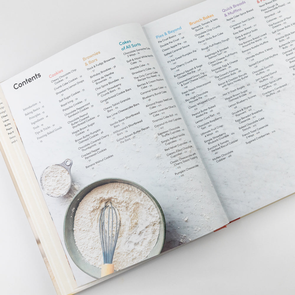 Open cookbook showing a list of recipes with illustrations of a whisk and measuring cup on a white background.