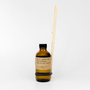 Brown bottle with black cap and wooden sticks on a white background