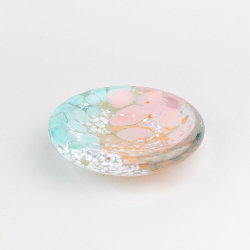 Decorative glass dish with pastel colors on a white background