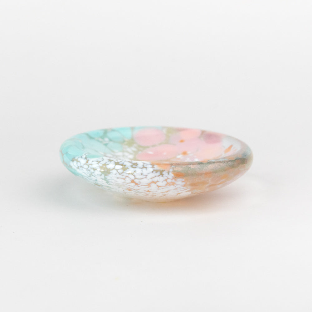 Decorative glass dish with pastel colors on a white background