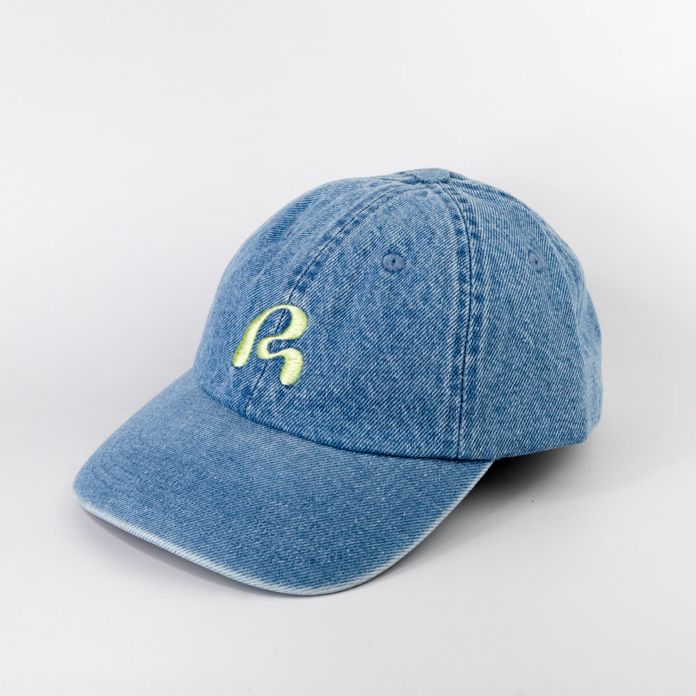 Blue denim cap with a yellow logo on a light gray background