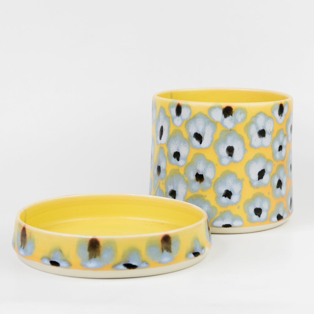 Two ceramic containers with floral pattern on a white background