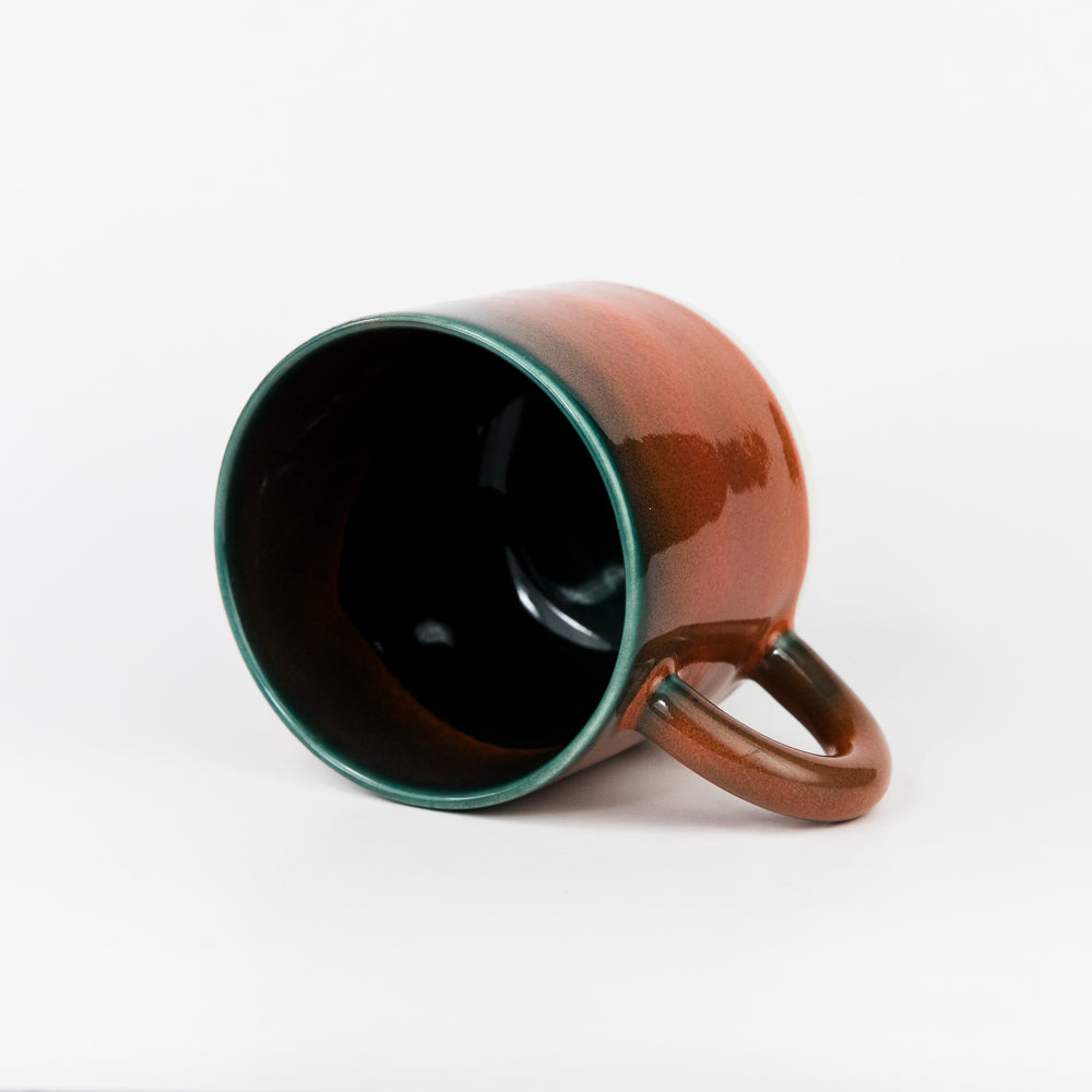 Brown mug with green interior on a white background