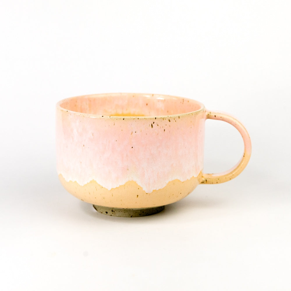 Pink ceramic mug with a speckled texture on a white background