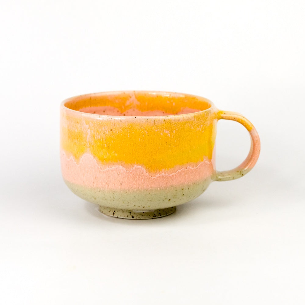 Ceramic mug with two-tone orange and beige design on a white background