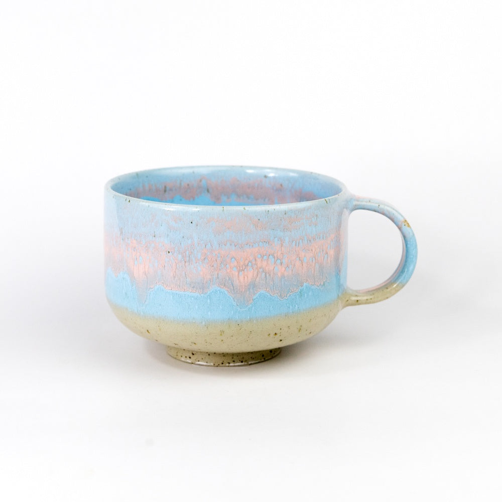 Ceramic mug with blue and pink gradient on a white background
