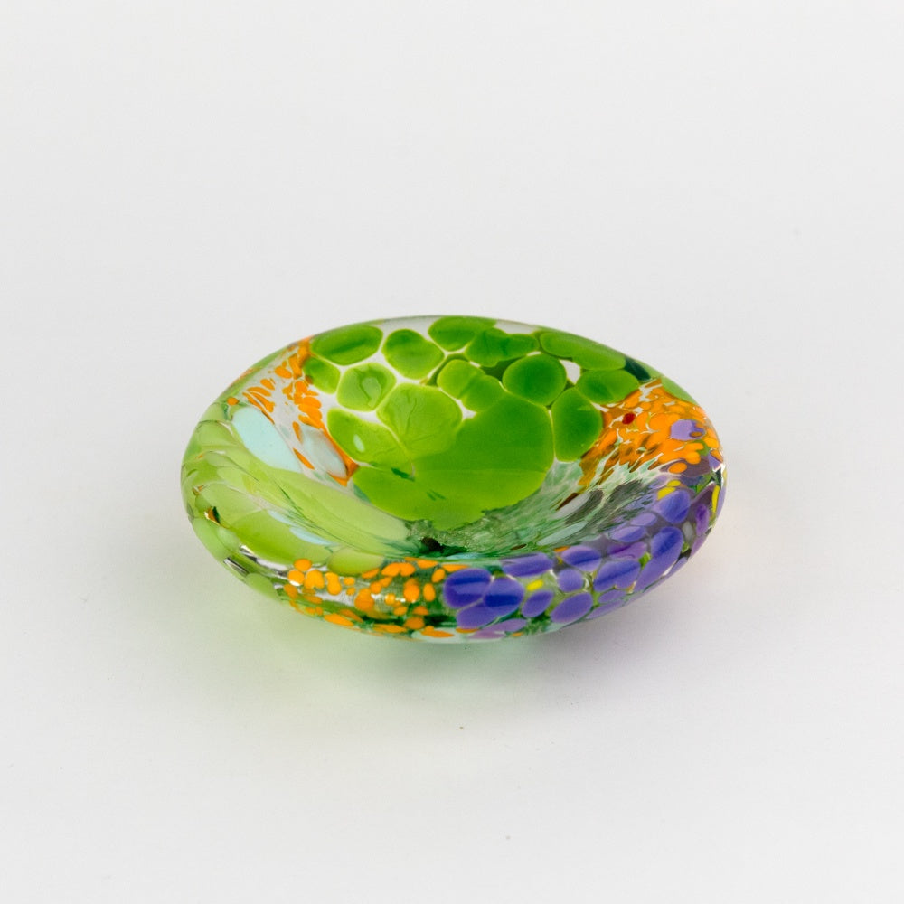 Decorative glass dish with green design on a white background