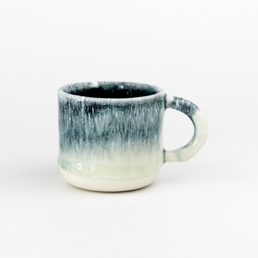 Ceramic mug with black to white gradient on a white background