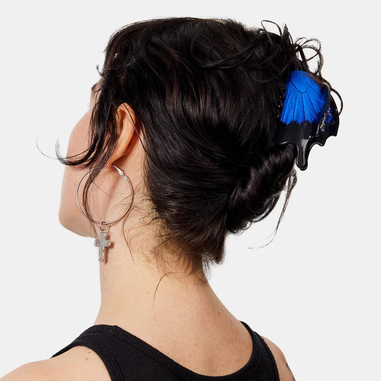 Black hair clip with a blue butterfly wing on a white background