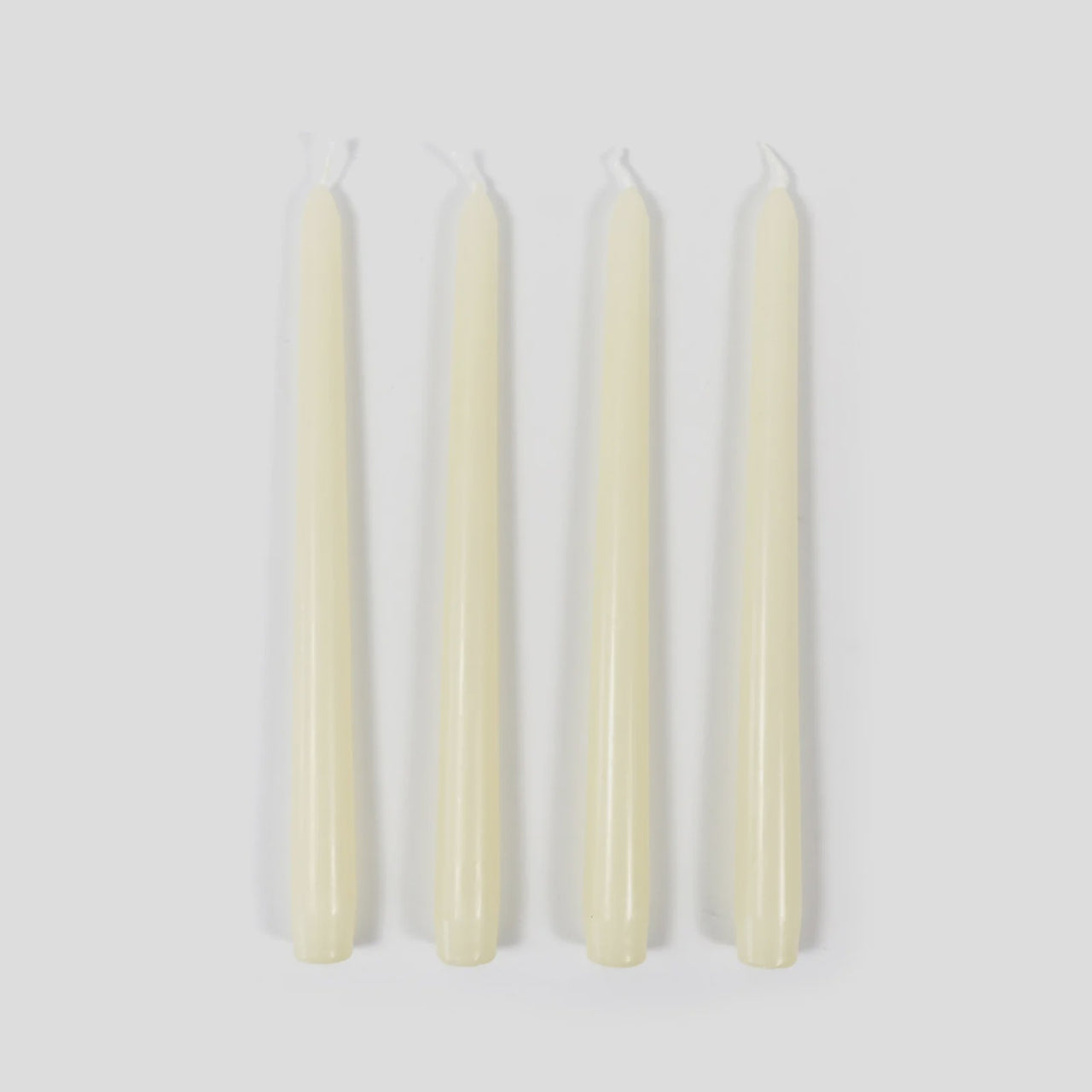 Four white candles on a light gray background