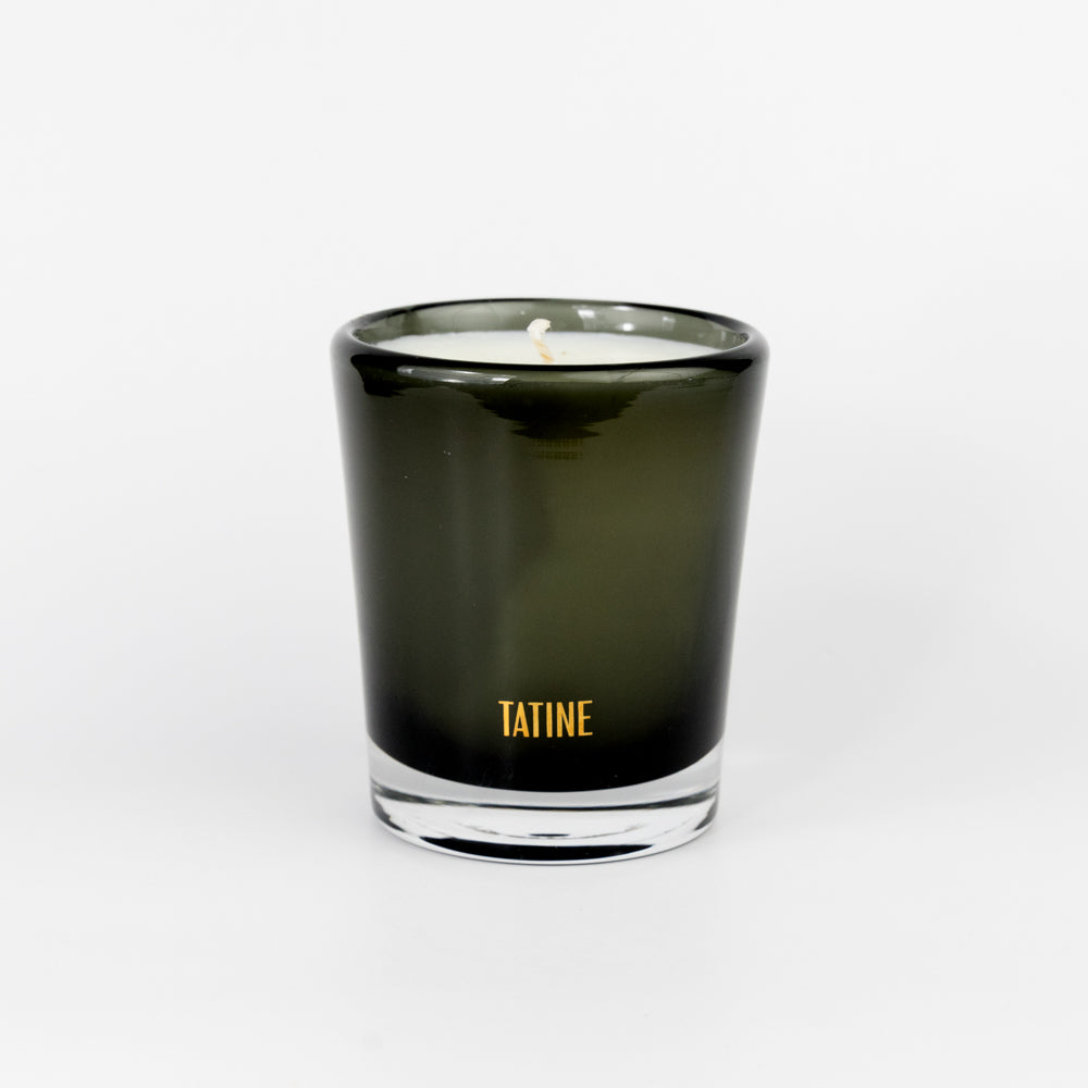 Tatine candle in a dark glass container on a white background