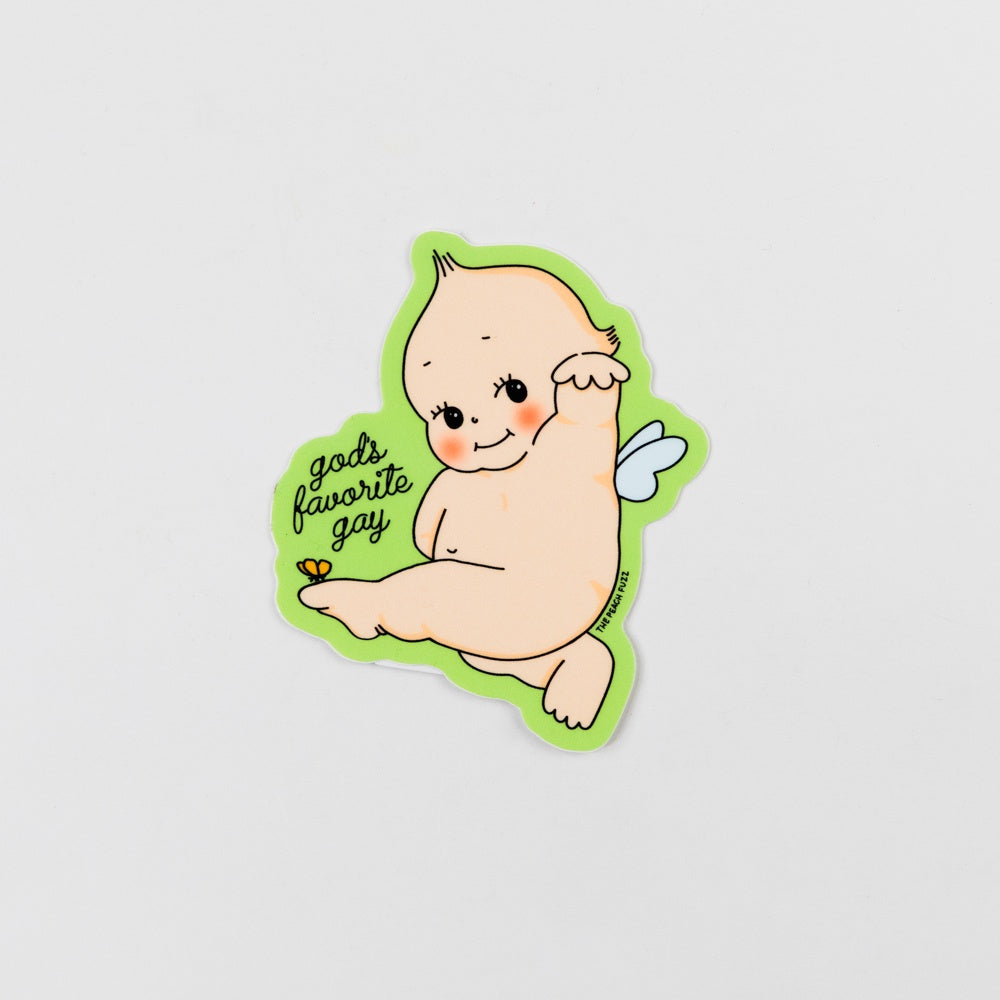 Sticker of a cartoon baby with angel wings and 'gods favorite gay' text on a light gray background