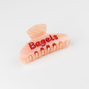 Pink hair clip with 'Bagels' text on a white background