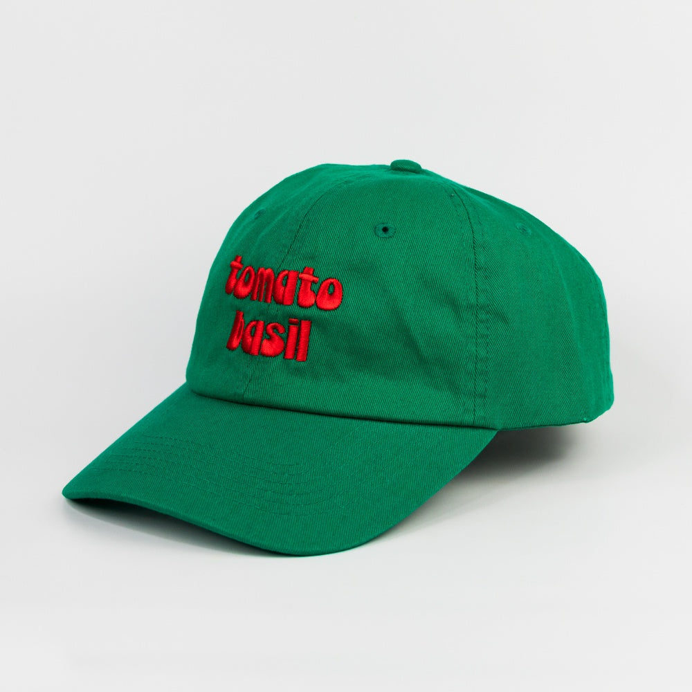 Green cap with red text 'tomato basil' on a light gray background