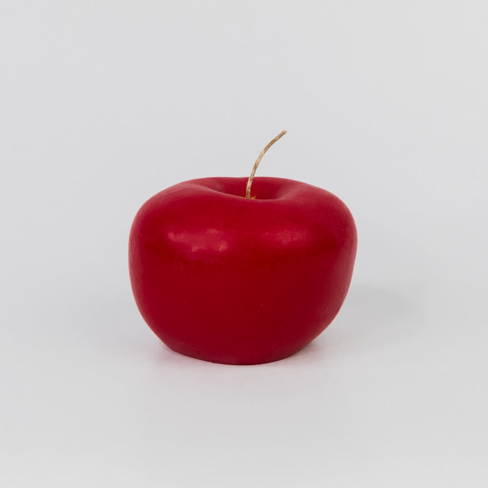 Red apple shaped candle on a white background