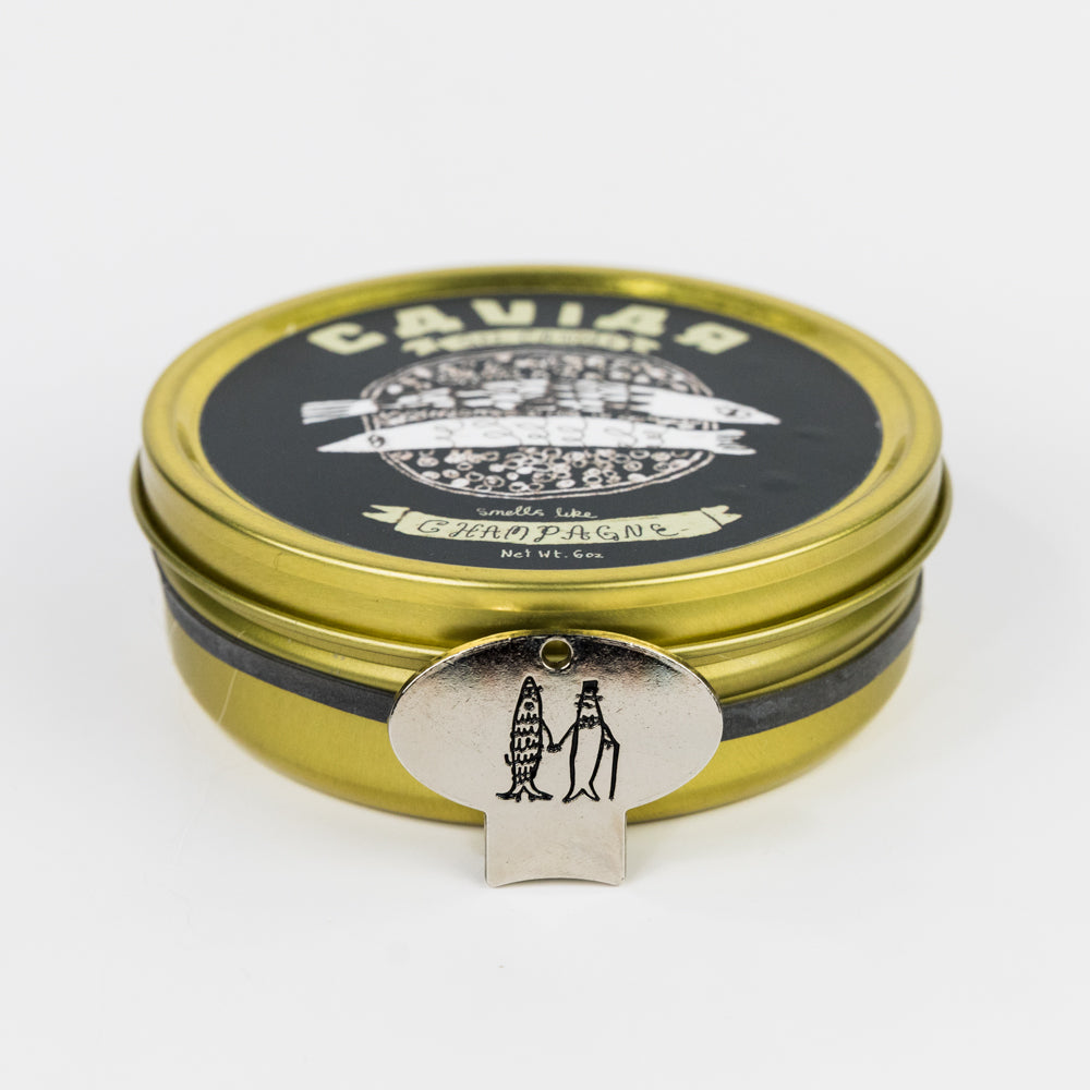 Gold and black caviar container with decorative lid on a white background