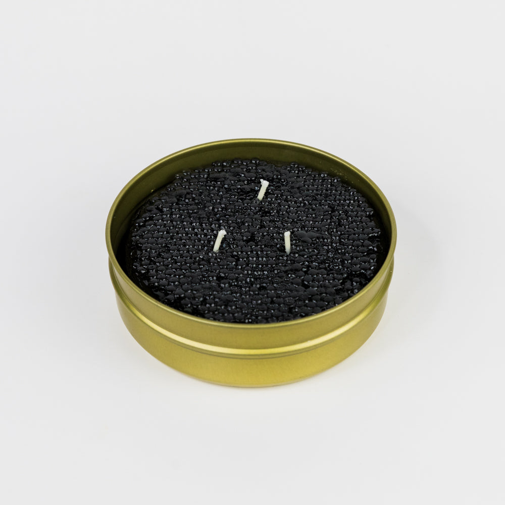 Caviar container lid with gold rim and black label on a white background
