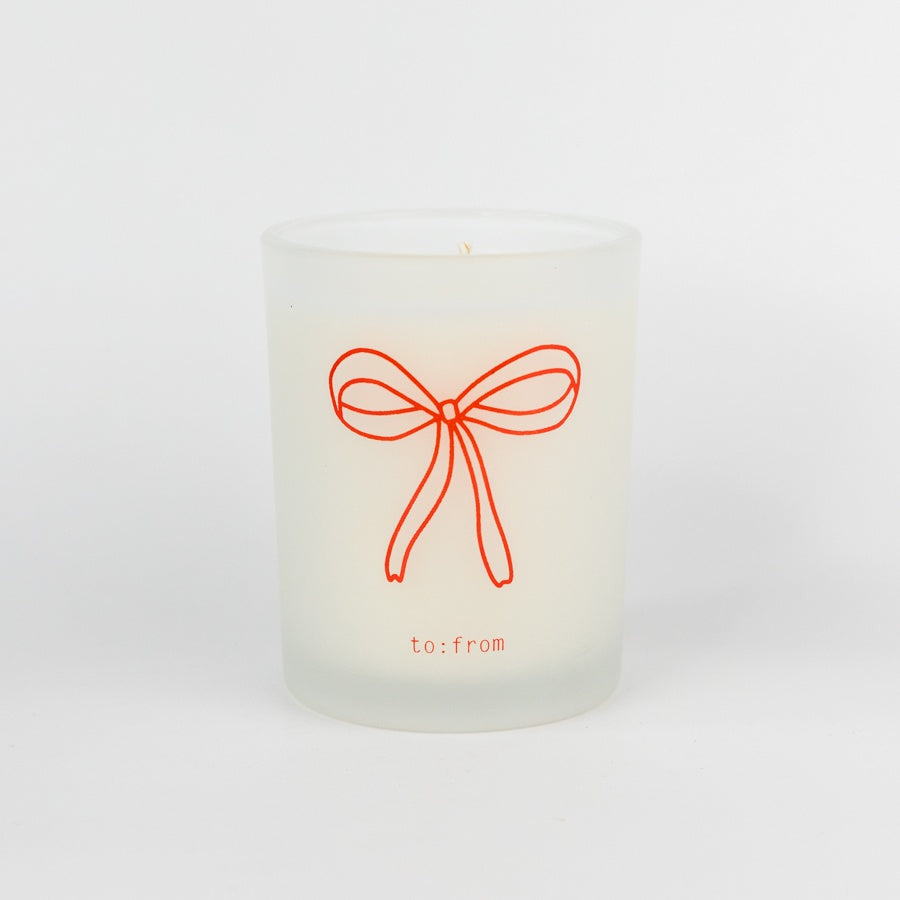 White candle with a red bow design and 'to:from' text on a white background