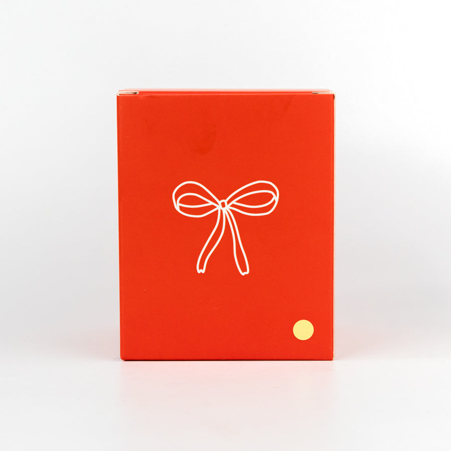 White candle with a red bow design and 'to:from' text on a white background