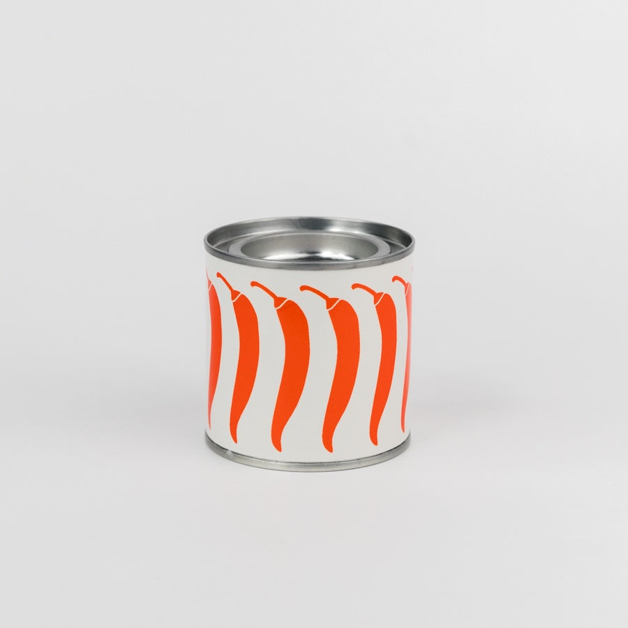 Metal can with red and white chili pepper design on a light gray background