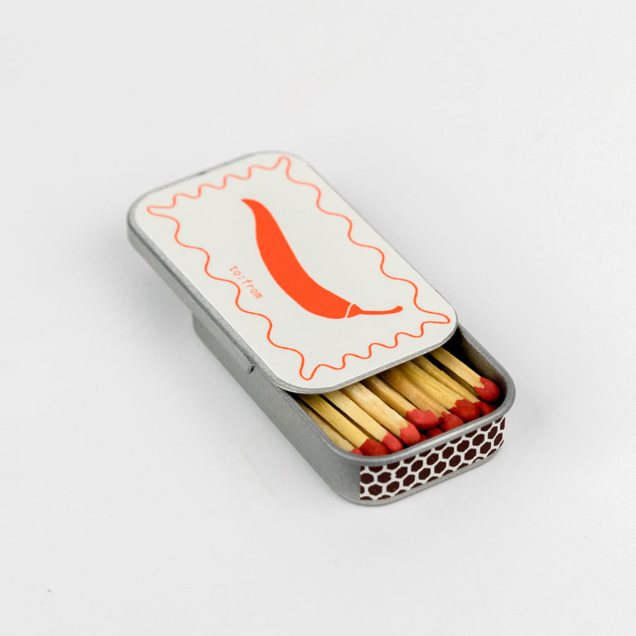 tin matchbox with a chili pepper design 