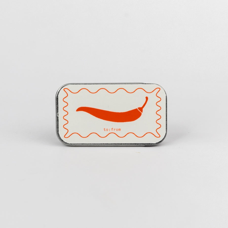 tin matchbox with a chili pepper design 