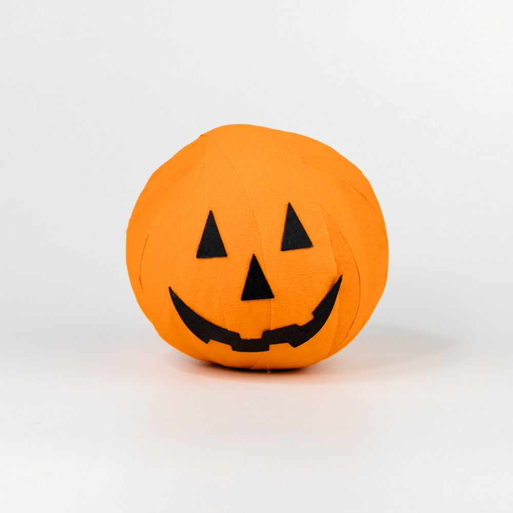 Orange ball with a jack-o'-lantern face on a white background