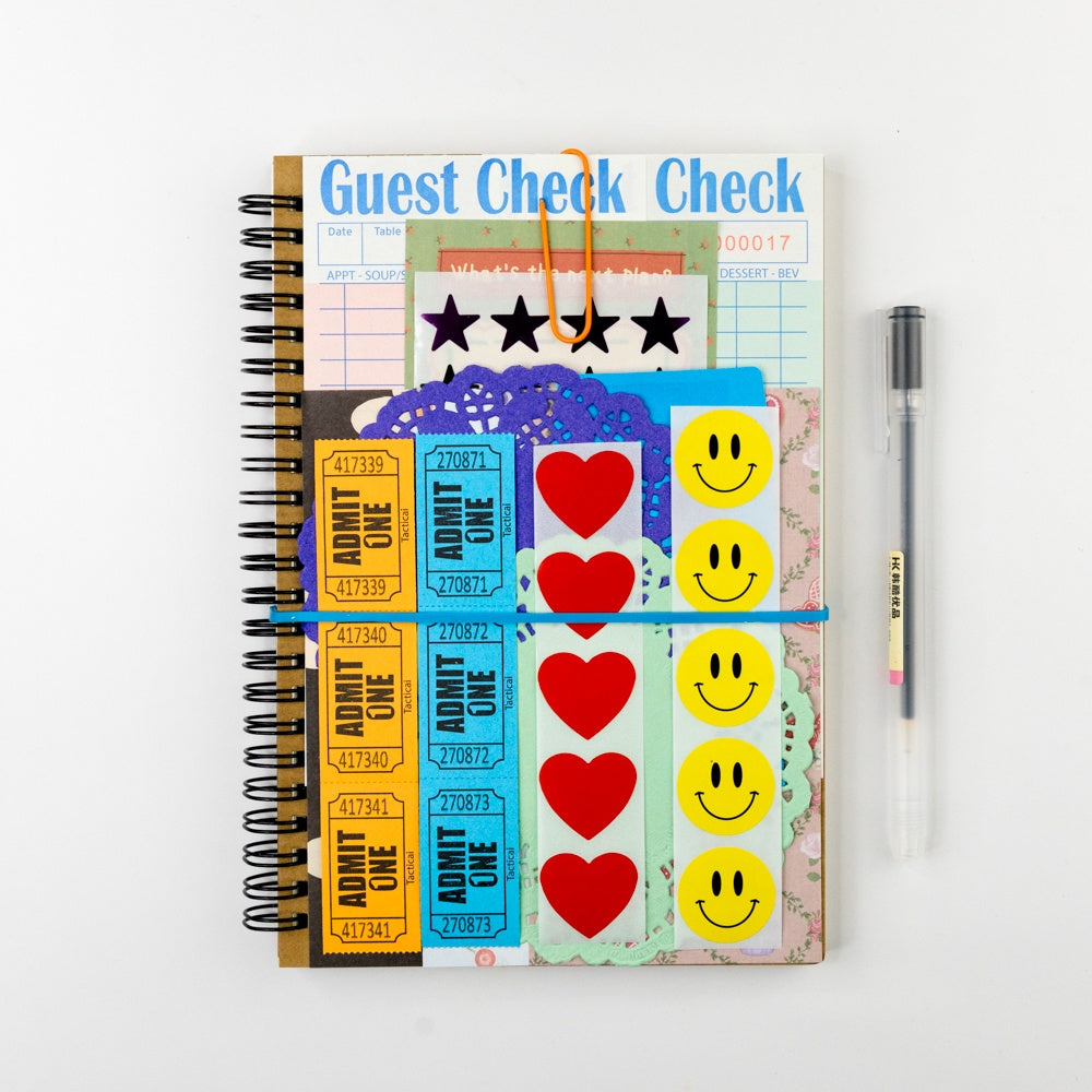 Notebook with colorful stickers and a pen on a white background
