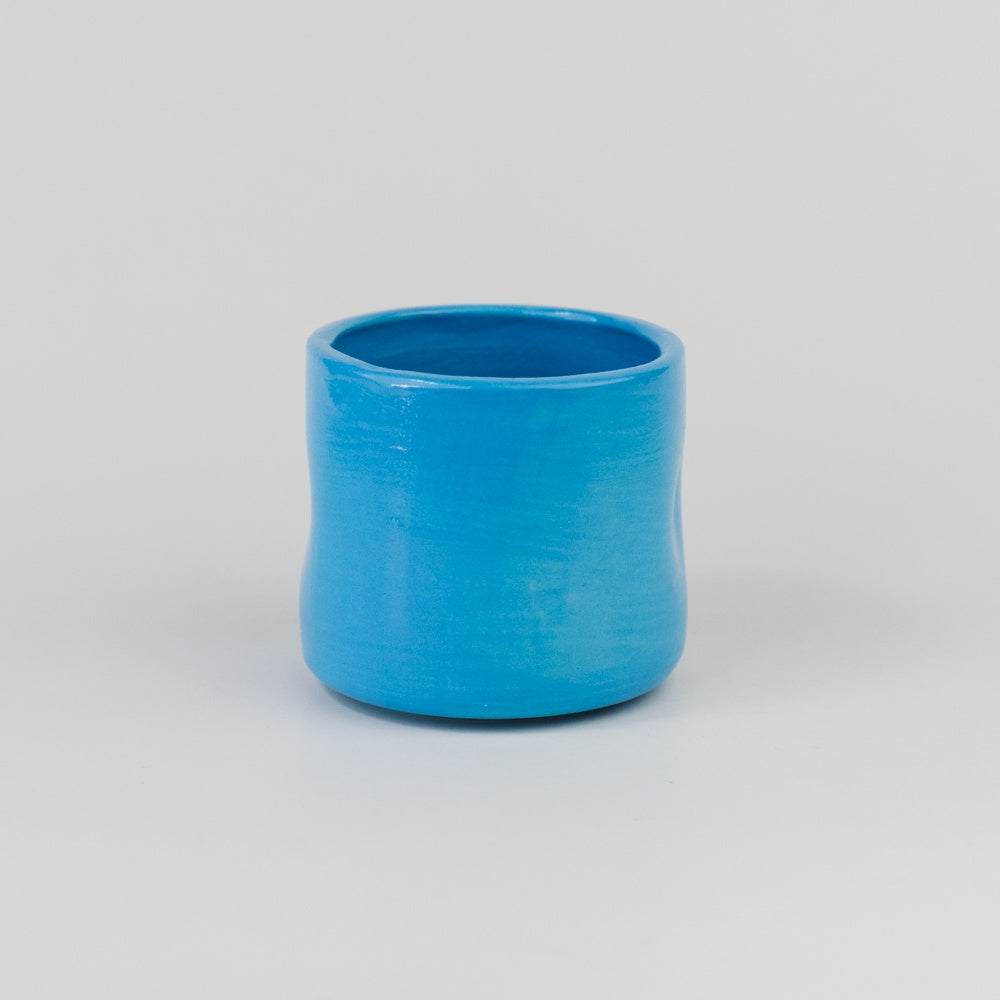Blue ceramic cup on a gray background
