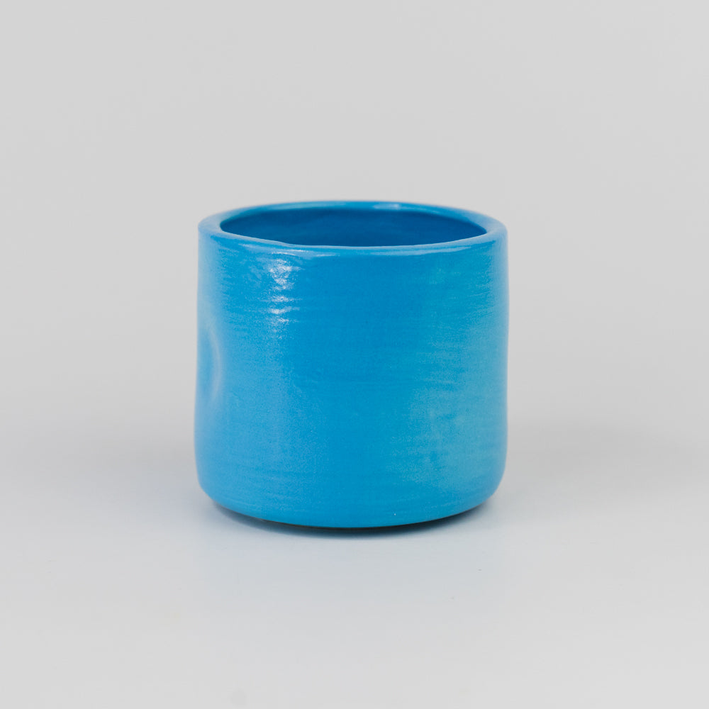 Blue ceramic cup on a gray background