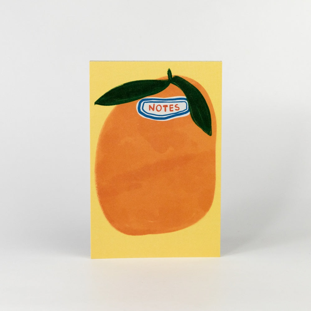 Notebook with an orange design and 'NOTES' label on a yellow background