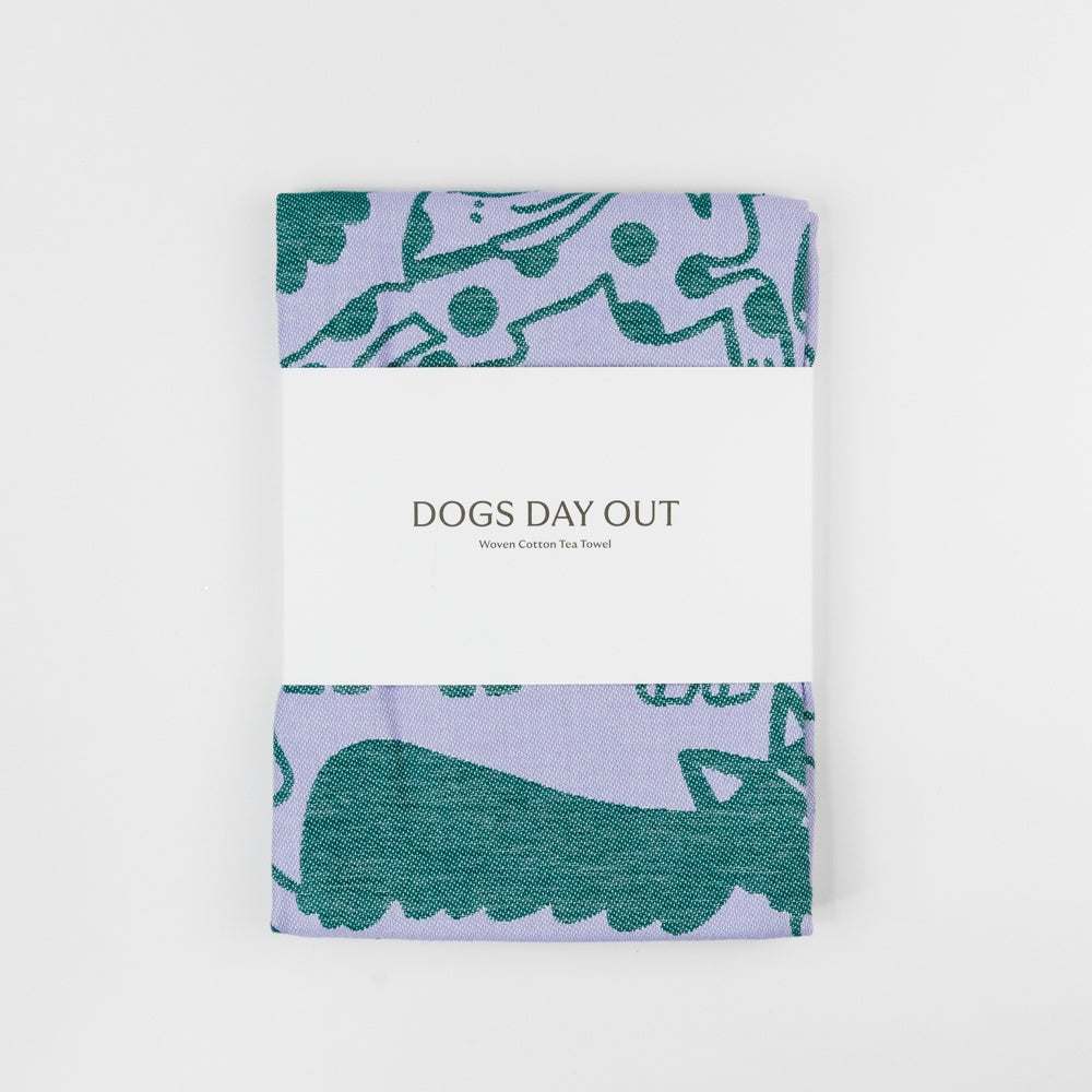 Product packaging with 'Dogs Day Out' text and dog illustrations on a light purple background