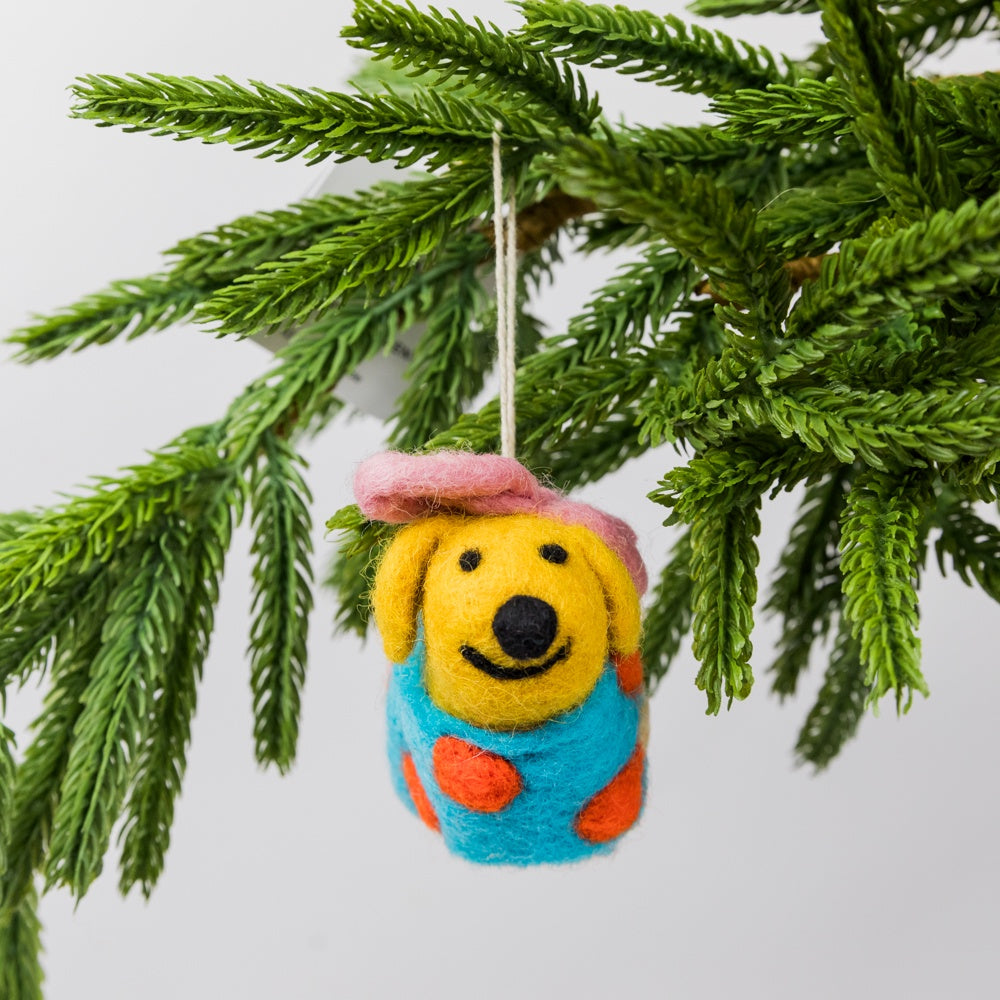 Felted dog ornament wrapped as a gift hanging on a Christmas tree branch.