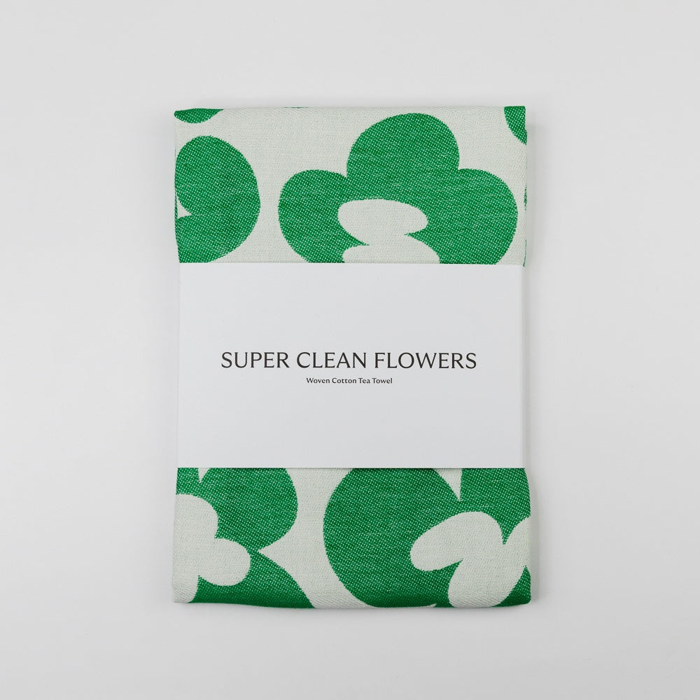 Green and white floral patterned towel with 'Super Clean Flowers' text on a light gray background